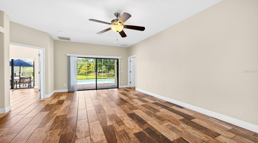 The bright Living Room features sliding glass doors that open to the back patio and pool, allowing NATURAL LIGHT to fill the space and creating an effortless connection between indoor and outdoor living.