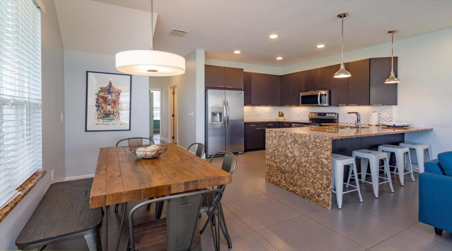 Bright And Open Dining Area Featuring Oversized Windows And Abundant Natural Light.