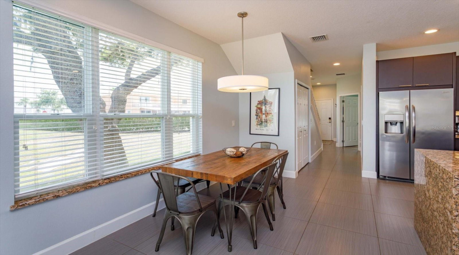 Bright And Open Dining Area Featuring Oversized Windows And Abundant Natural Light.