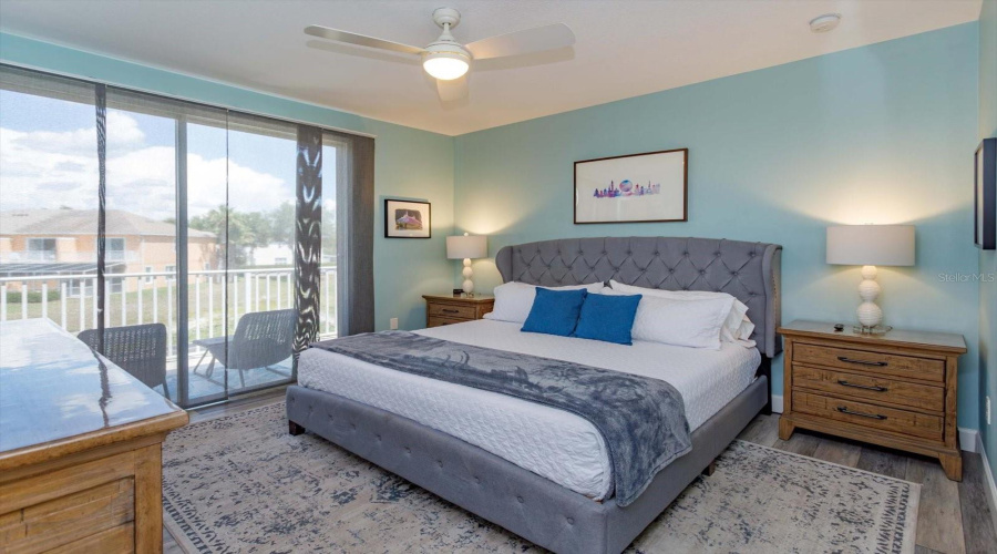 Spacious Primary Suite Featuring Private Balcony Access Overlooking The Peaceful Pond And Community Grounds.