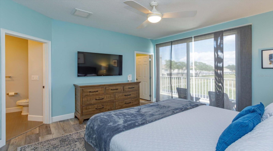 Spacious Primary Suite Featuring Private Balcony Access Overlooking The Peaceful Pond And Community Grounds.