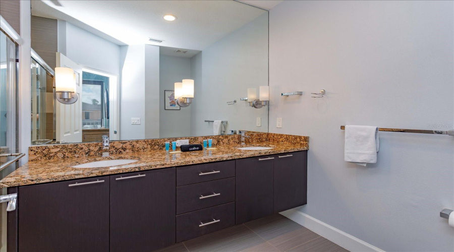 Elegant Primary Bathroom With Dual Vanities, Granite Countertops, And Contemporary Finishes.