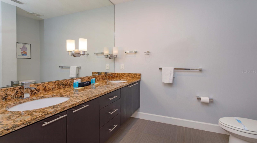 Elegant Primary Bathroom With Dual Vanities, Granite Countertops, And Contemporary Finishes.