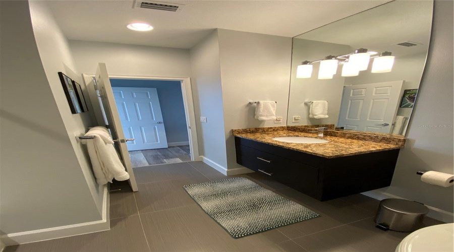 Stylish Guest Bathroom Featuring A Granite Countertop, Floating Vanity, And Modern Finishes.
