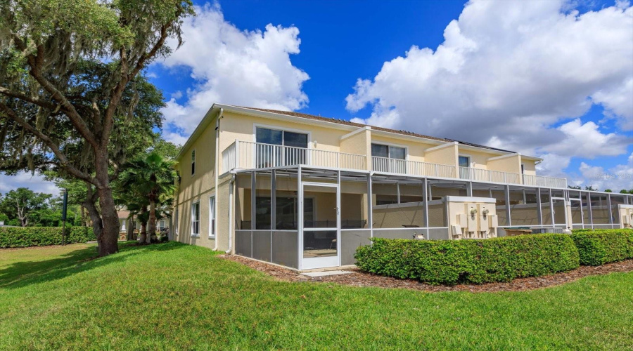 Rear Exterior View Showcasing The Desirable Corner-Unit Location With Screened-In Lanai, Private Balcony, And Added Privacy.
