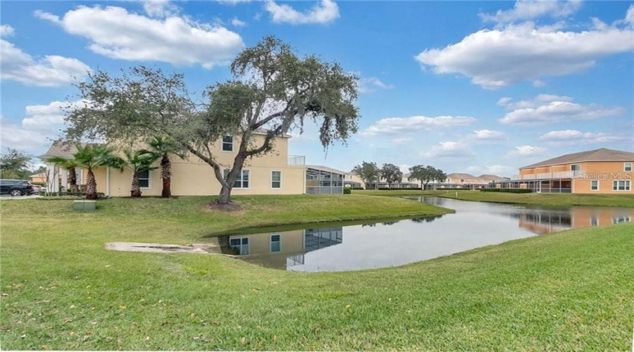 Side View Showcasing The Peaceful Pond And Surrounding Mature Trees.