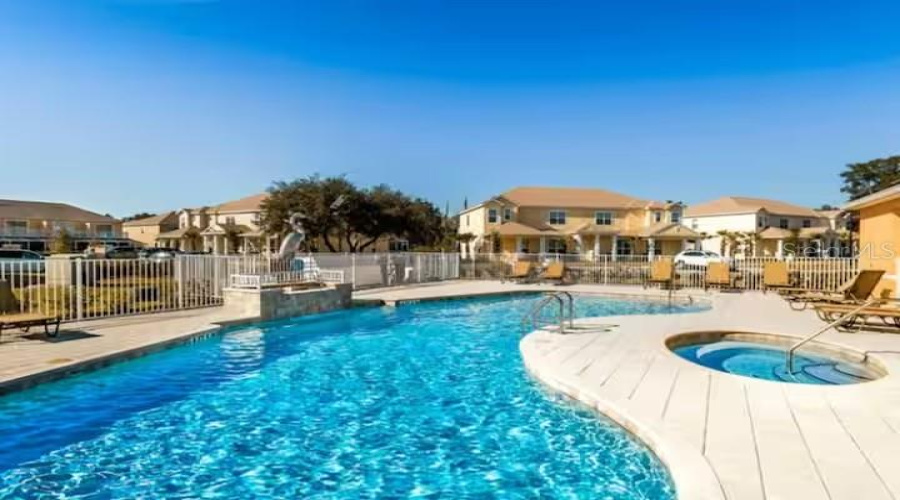 Resort-Style Community Pool And Spa Area With Spacious Sundeck Seating And Relaxing Atmosphere.