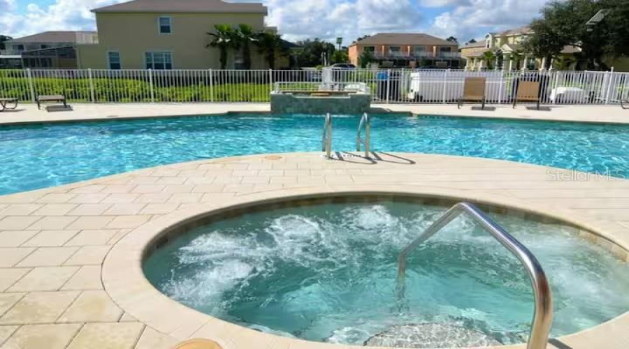 Resort-Style Community Pool And Spa Area With Spacious Sundeck Seating And Relaxing Atmosphere.