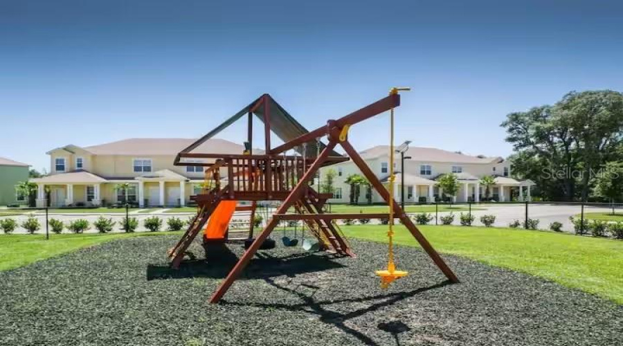 Community Playground Area With Open Green Space, Perfect For Outdoor Recreation And Family Enjoyment.