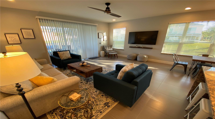 Bright And Inviting Living Room Featuring Large Windows, Abundant Natural Light, And Direct Access To The Outdoor Living Area.