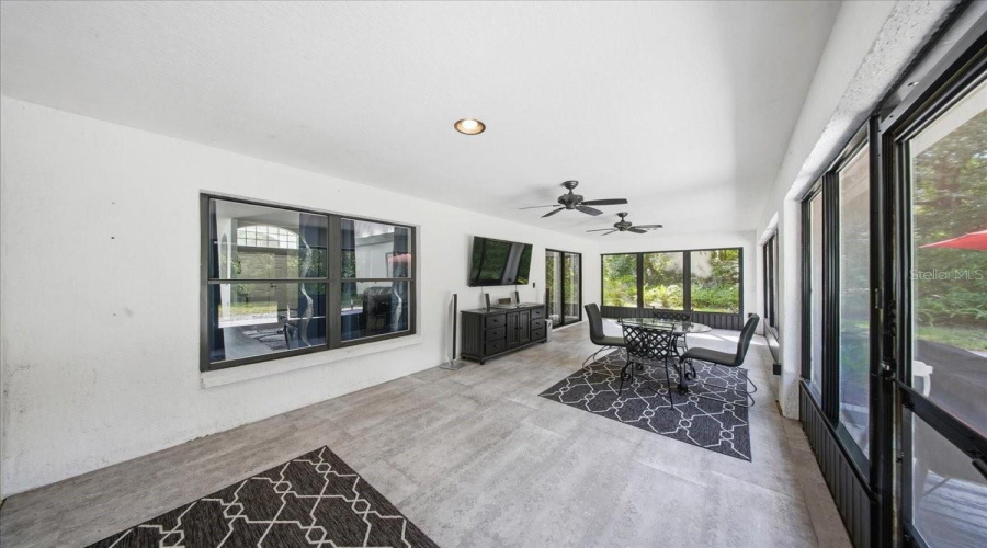 Expansive Screened Lanai, Enhanced With Ceramic Tile Flooring And 65&Quot; Wall-Mounted Television.