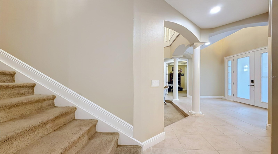 Staircase To 2Nd Floor And 4 More Bedrooms. View Of Double Door Entry Foyer With 2 Architectural Columns, 2 Additional Bedrooms, Full Bath, And One Of Two 2-Car Garages.
