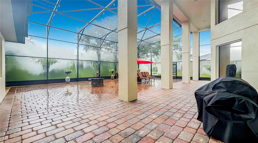 Screen Enclosed, 2-Story Screen Enclosure With Paver Flooring And Backing To Wooded Area.