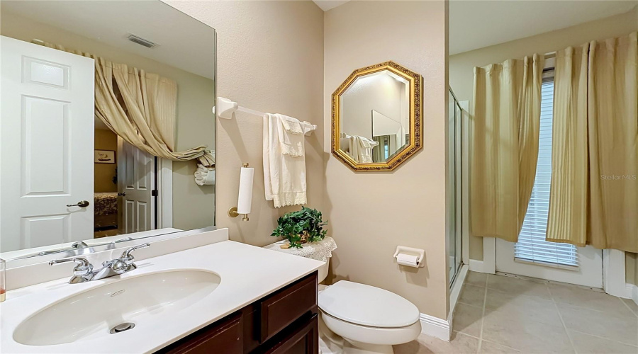 Downstairs Full Bath And Exterior Door To Screen Enclosed Patio.