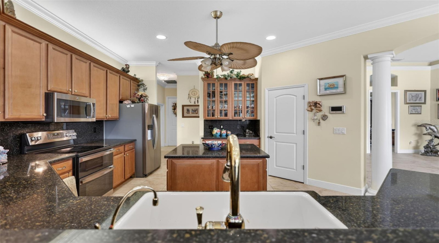Open-Concept Family Living Spaces Showcase Tray Ceilings, Crown Molding, Custom Built-In Shelving, And Expansive Views Of The Pool And Surrounding Acreage.