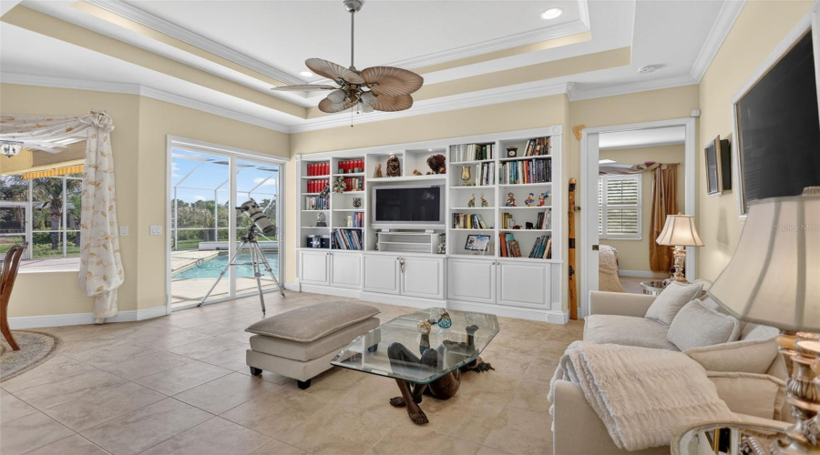 The Inviting Family Room Features A Custom Built-In Entertainment Center, Tray Ceiling, And Seamless Access To The Outdoor Living Spaces.