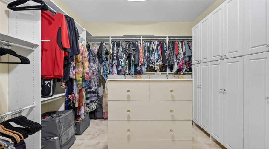 The Custom-Designed Primary Closet Provides Exceptional Organization With Built-In Cabinetry, Extensive Hanging Space, And Integrated Drawer Storage.