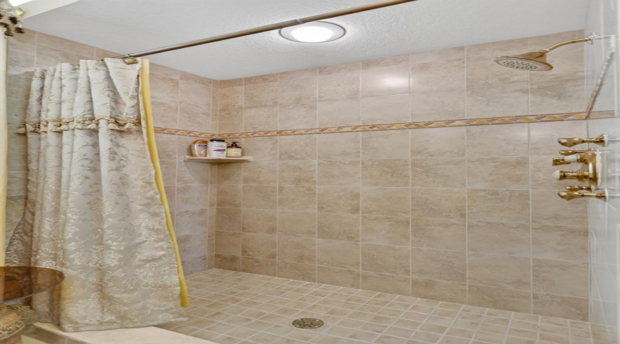 The Guest Bath Showcases Timeless Tile Finishes, A Walk-In Shower, And Convenient Access To The Adjacent Guest Accommodations.