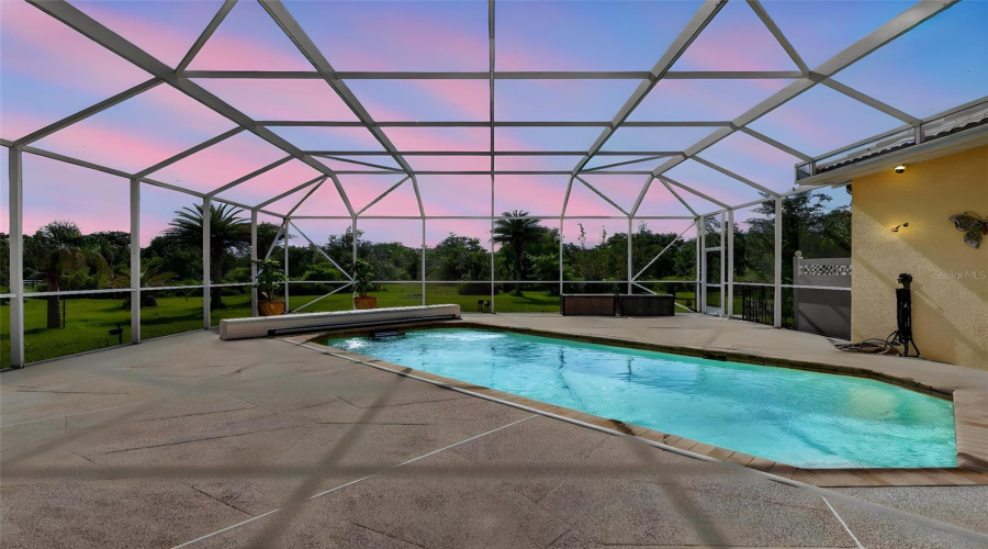 As The Sun Sets, The Pool Enclosure Transforms Into A Serene Private Oasis, Showcasing Stunning Evening Skies And Tranquil Outdoor Living.