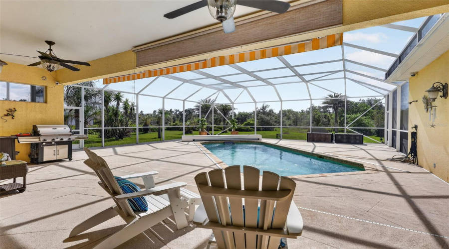 The Covered Lanai Seamlessly Blends Indoor And Outdoor Living With Generous Entertaining Space, Retractable Awnings, Ceiling Fans, And Scenic Views Beyond.