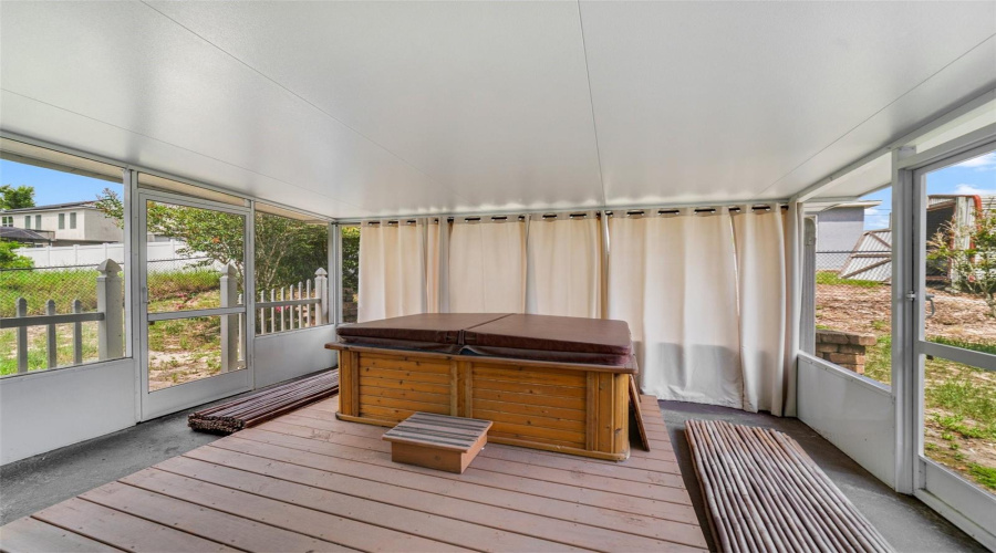 Step Through Sliding Glass Doors To The Screened Back Porch, Where A Hot Tub Invites Relaxation As You Take In The Peaceful Surroundings.