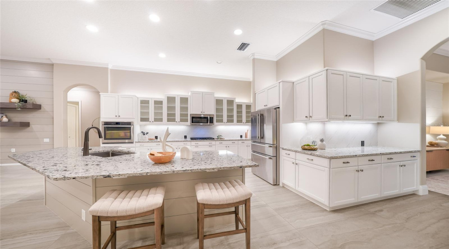Updated Gourmet Kitchen With Stainless Steel Appliances, Sprawling Counter Height Stone Counters, Wood Cabinetry, Large And Customized Walk-In Pantry