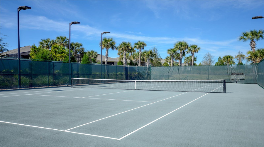 Clay Tennis Court. The Court Is Lighted For Nighttime Play.