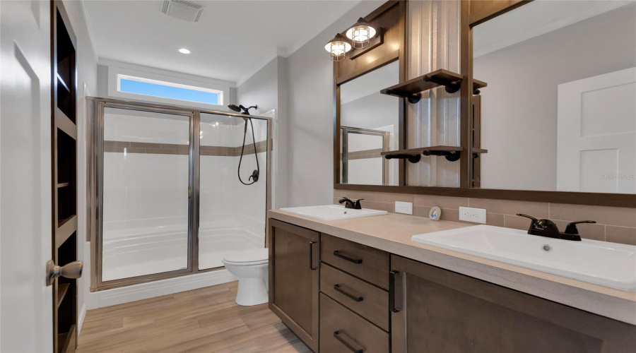 Primary Suite Bathroom With Double Sinks And Spacious Shower That Features A Bench