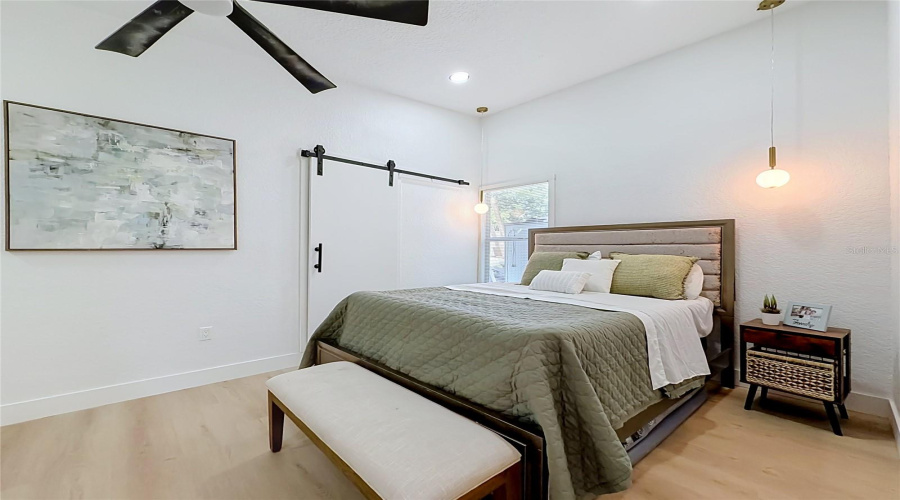 Comfortable Primary Bedroom With High Ceilings And Modern Lighting.
