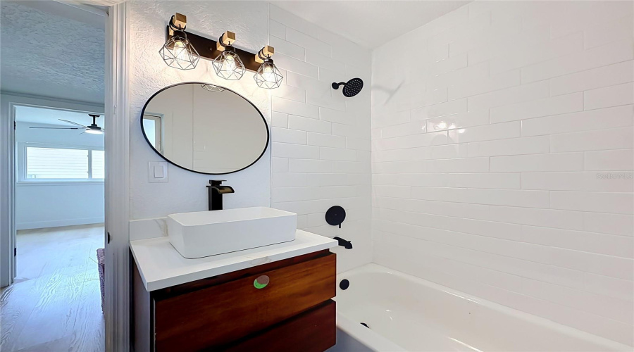 Updated Bathtub And Shower With Floor-To-Ceiling Tile.