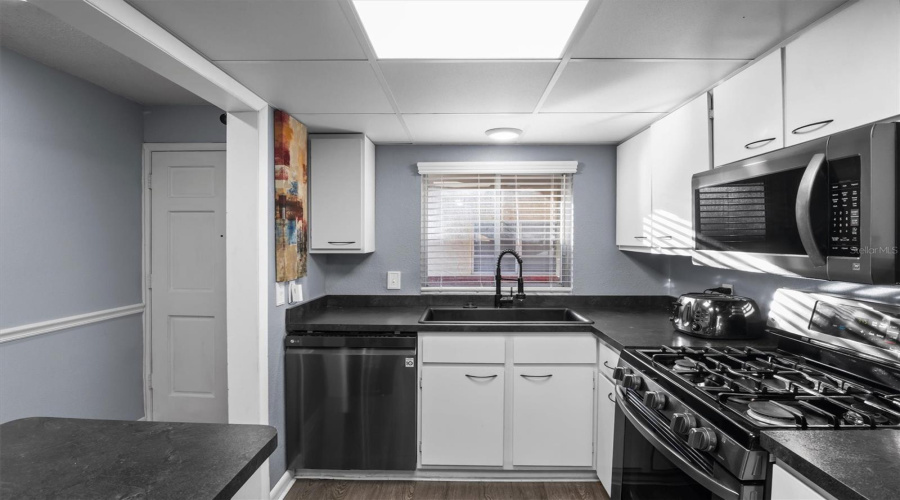 The Kitchen Has A Gas Stove And Stainless Steel Appliances