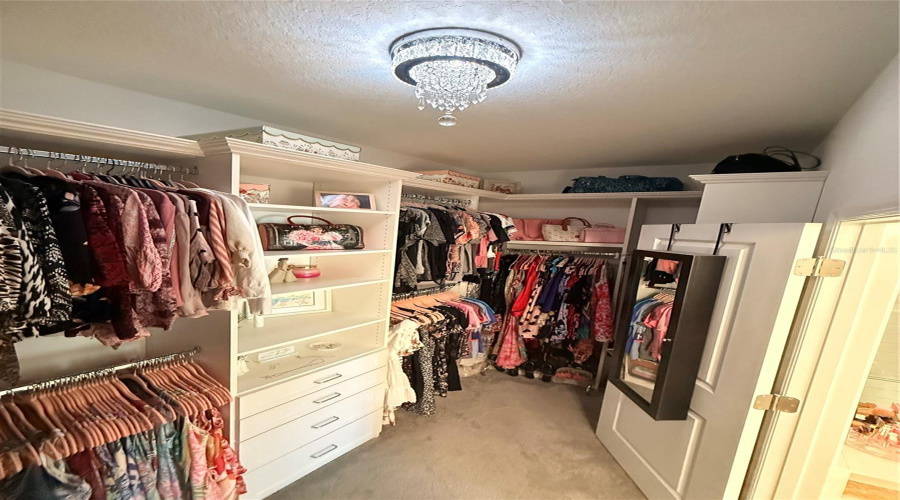 Custom Primary Walk-In Closet By Closets By Design With Crystal Chandelier