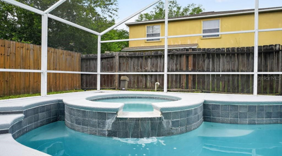 Screen -Enclosed Spa With Spillover Waterfall Into The Pool.