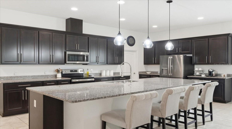 A Sleek Modern Kitchen Anchored By A Massive Island Creates A Stunning Centerpiece For Everything From Morning Coffee To Unforgettable Gatherings.