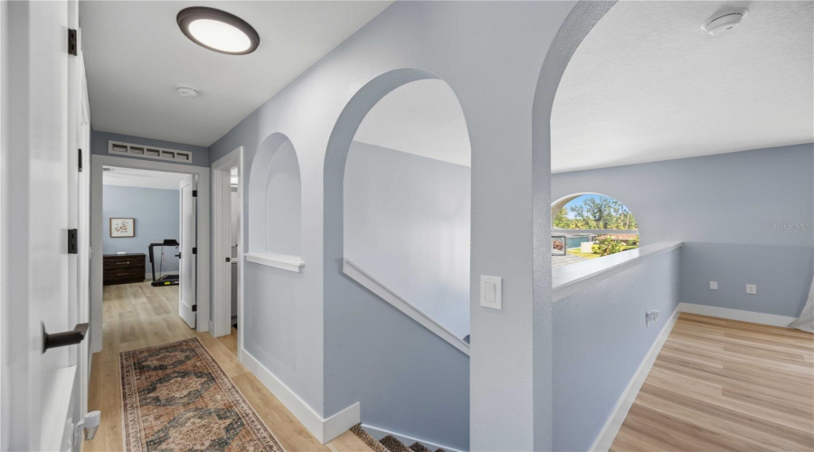 Upstairs Hallway Showing Vaulted Ceiling From The Foyer And Entry To Primary Bedroom