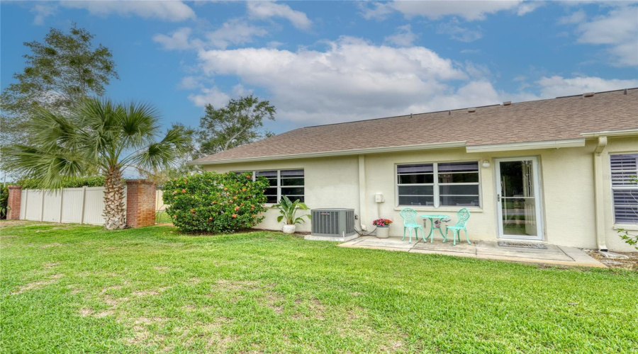 Rear Exterior And Green Space Offering A Peaceful Residential Setting.