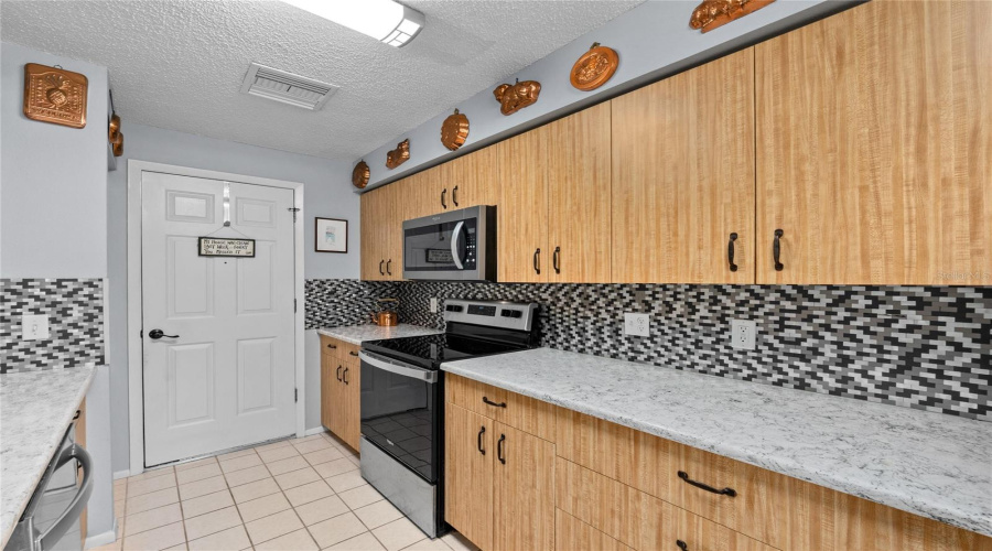 Well-Appointed Kitchen With Stainless-Steel Appliances And Ample Workspace.