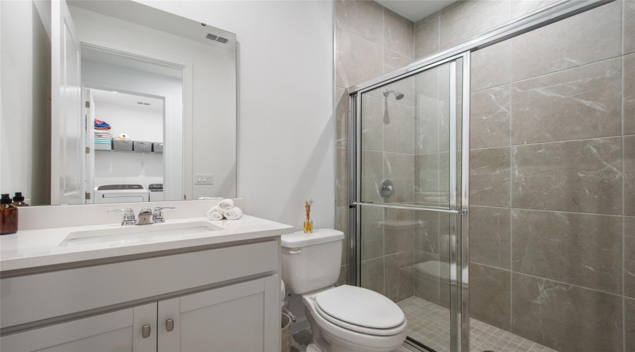 Hall Bath Adjacent To Bedroom 4 Has A Walk In Shower With Floor To Ceiling Tile And A Sliding Door For Easy Access. Single Vanity Has Quartz Countertops And A Lovely Transitional Design.