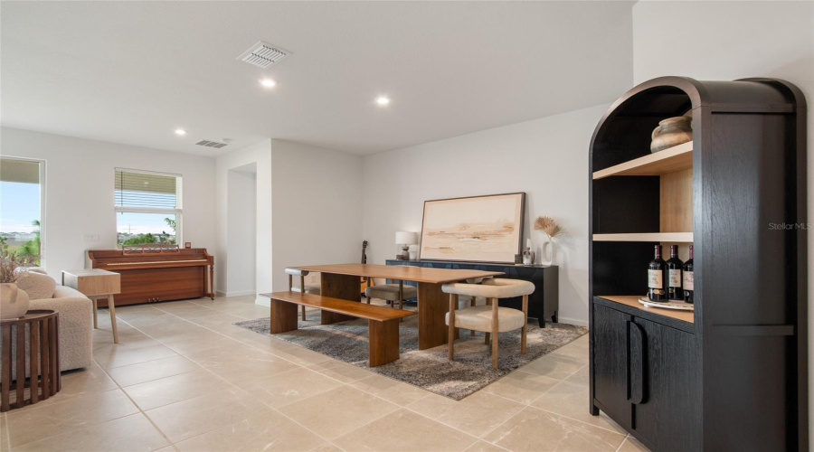 Upon Entering The Great Room You Are Greeted By A Free Flow Dedicated Dining Area, A View Of The Unobstructed Rear Yard And Beautiful Neutral Tile Flooring.