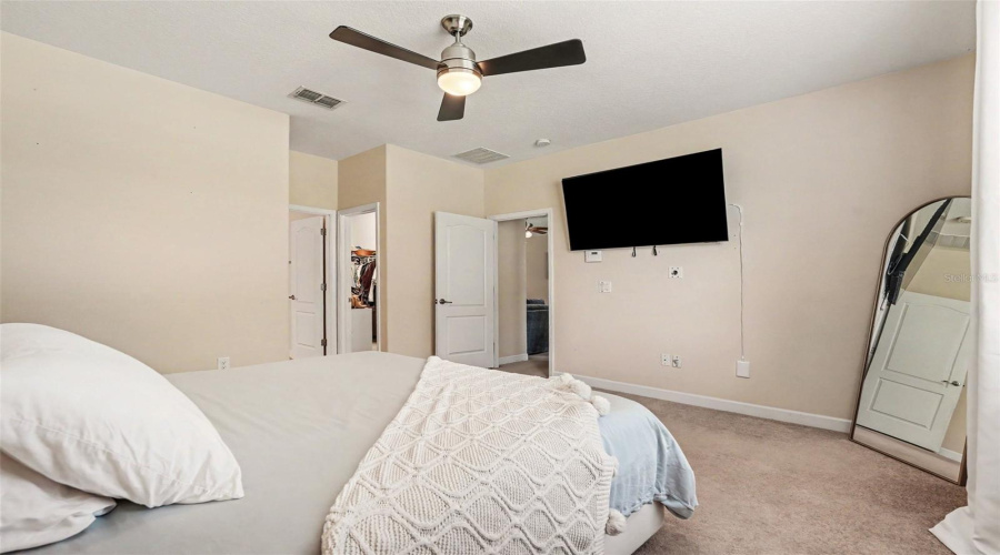 Primary Bedroom Suite Third Angle Showing Walk-In Closet Open, Tv Mount, And En-Suite Access In Tampa Fl 33647