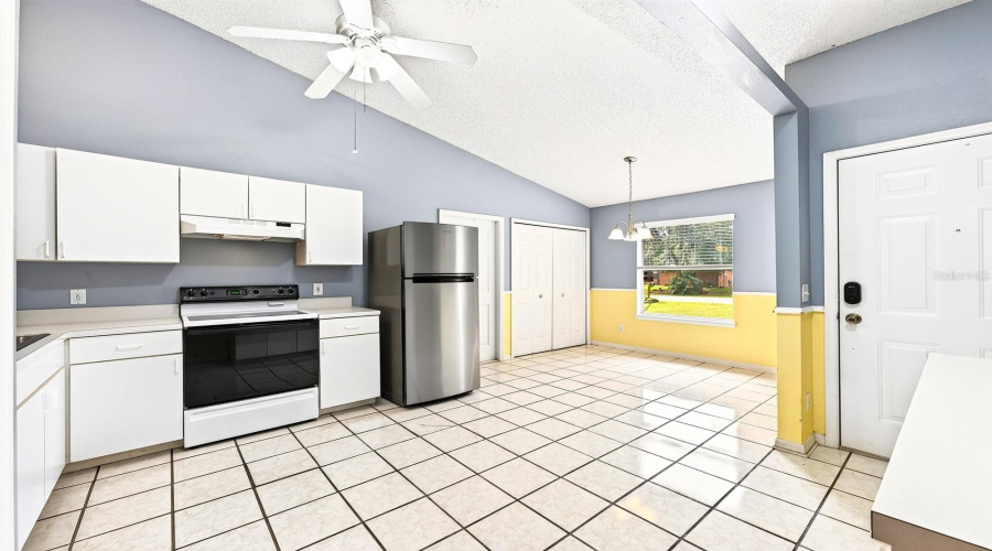 The Kitchen Offers Crisp White Cabinetry, A Closet Pantry And A Spacious Dining Area Filled With Natural Light.