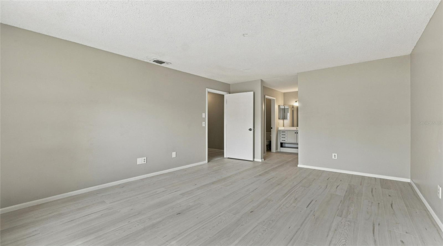 Light-Toned Wood-Finish Flooring, Neutral Wall Paint, And White Trim Throughout