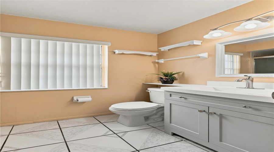 White Vanity With Brushed Nickel Hardware, Integrated Sink, And Wall-Mounted Mirror