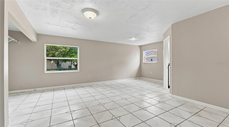 Tiled Flooring, Neutral Wall Tones, Multiple Windows, And Overhead Lighting Fixtures