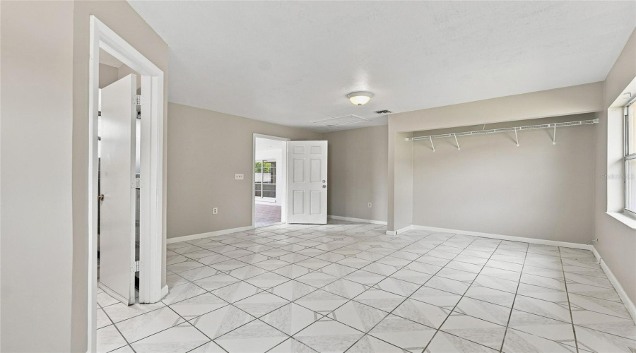 Tiled Flooring, Neutral Wall Tones, Interior Lighting, And An Open Doorway