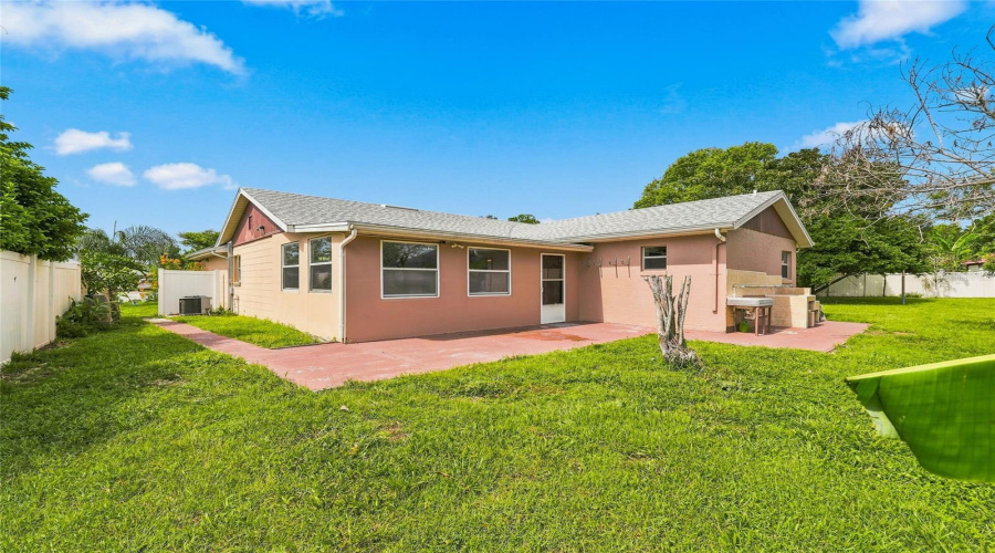 Expansive Grassy Yard With Concrete Patio, Exterior Access, And A Built-In Outdoor Utility Sink