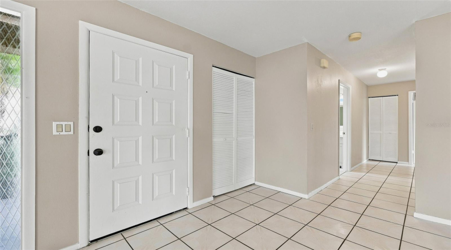 Entryway Featuring A Paneled Door, Tile Flooring, And A Side Light