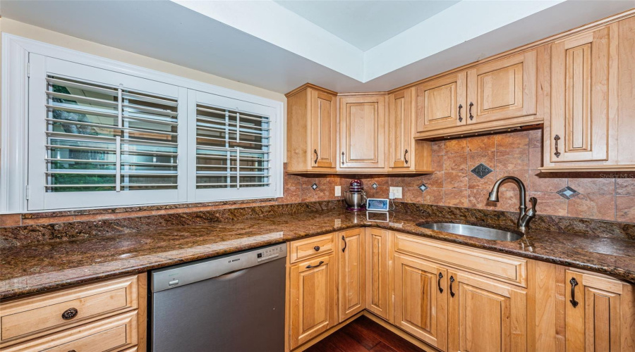 Well Appointed Kitchen With Granite Counters, Stainless Appliances, Privacy Shutters, And Wood Cabinets.