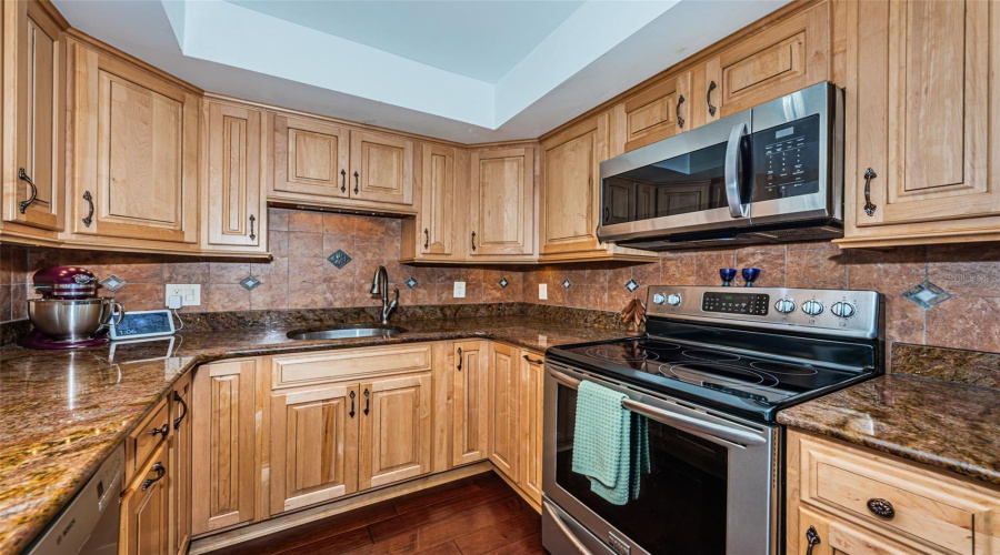 Well Appointed Kitchen With Granite Counters, Stainless Appliances, Privacy Shutters, And Wood Cabinets.