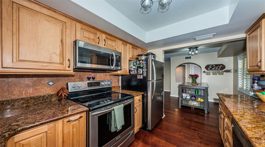 Well Appointed Kitchen With Granite Counters, Stainless Appliances, Privacy Shutters, And Wood Cabinets.